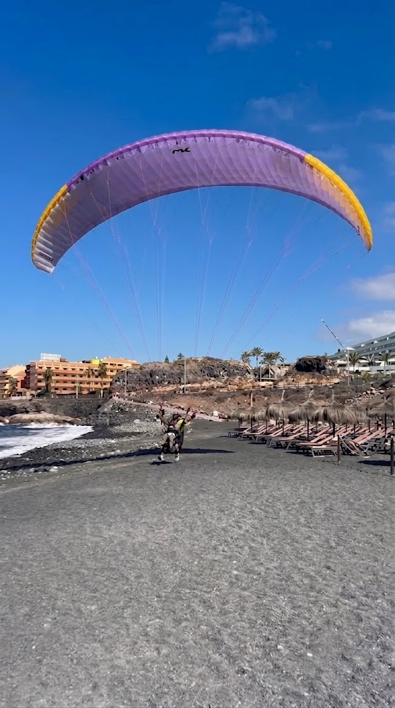 Parapente aterrizando en la playa
